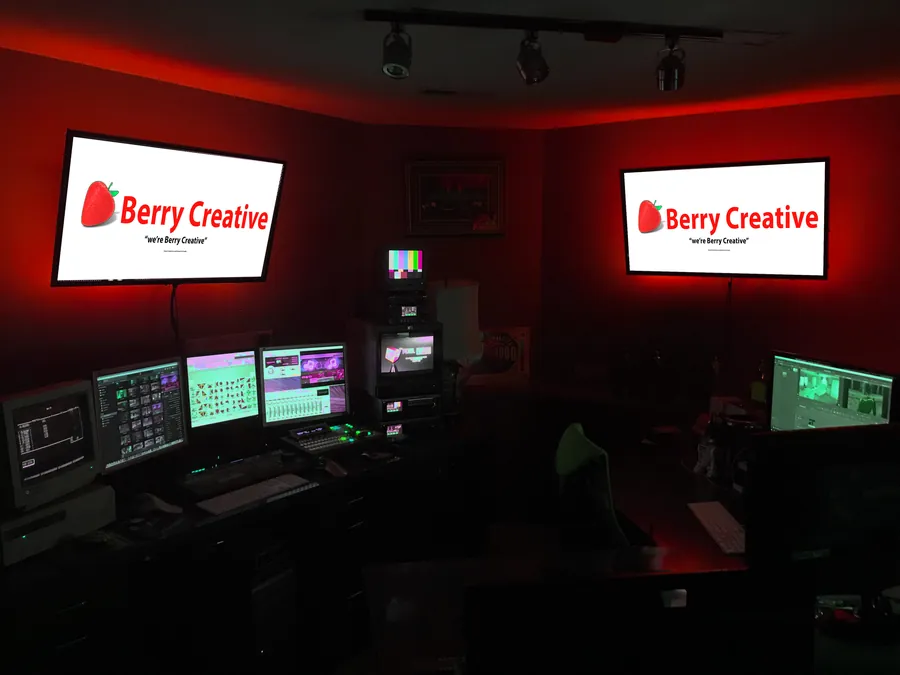 The Berry Creative edit suite, lit red, with the logo on the monitors